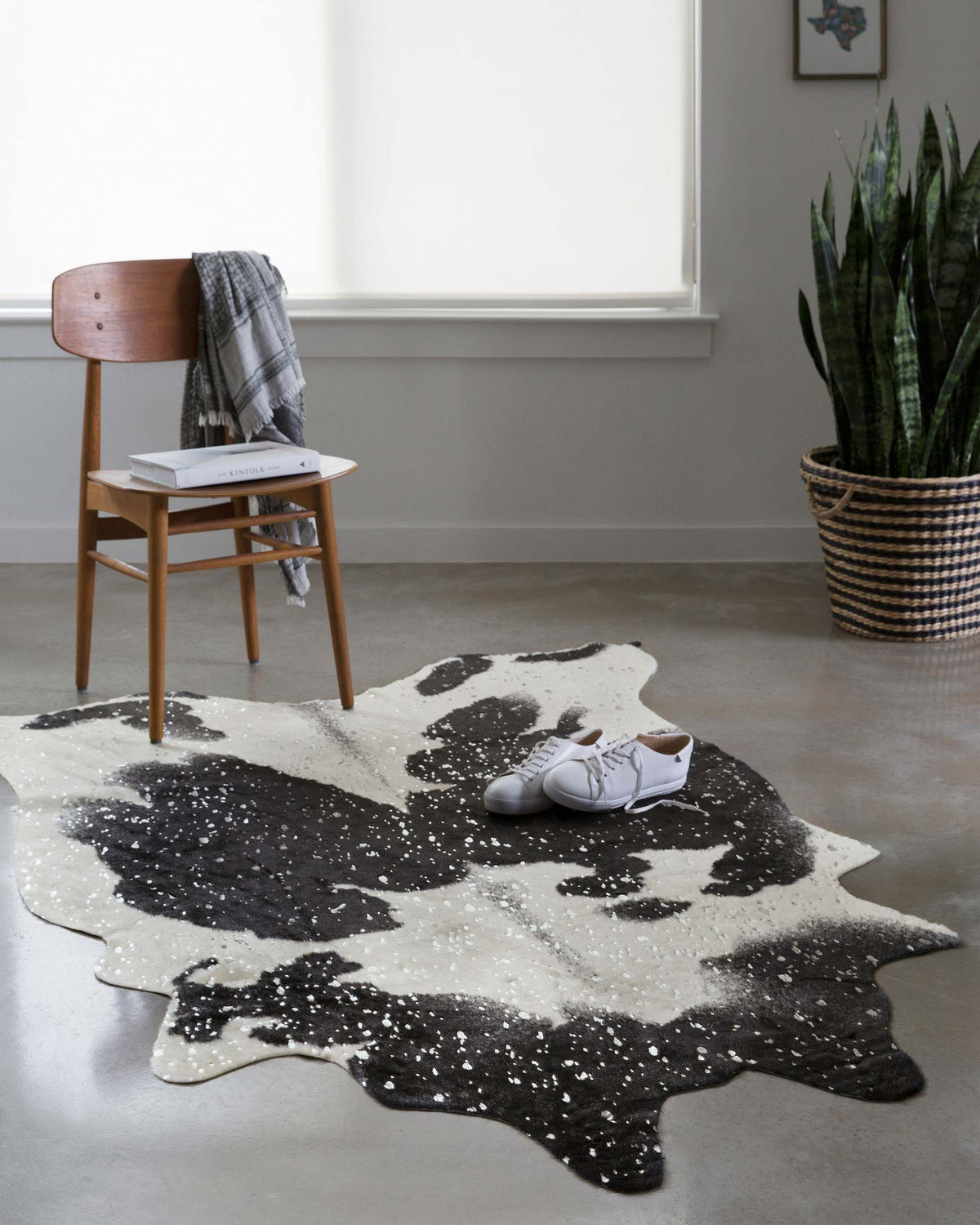 Black and silver mottled abstract area rug with irregular cowhide shape