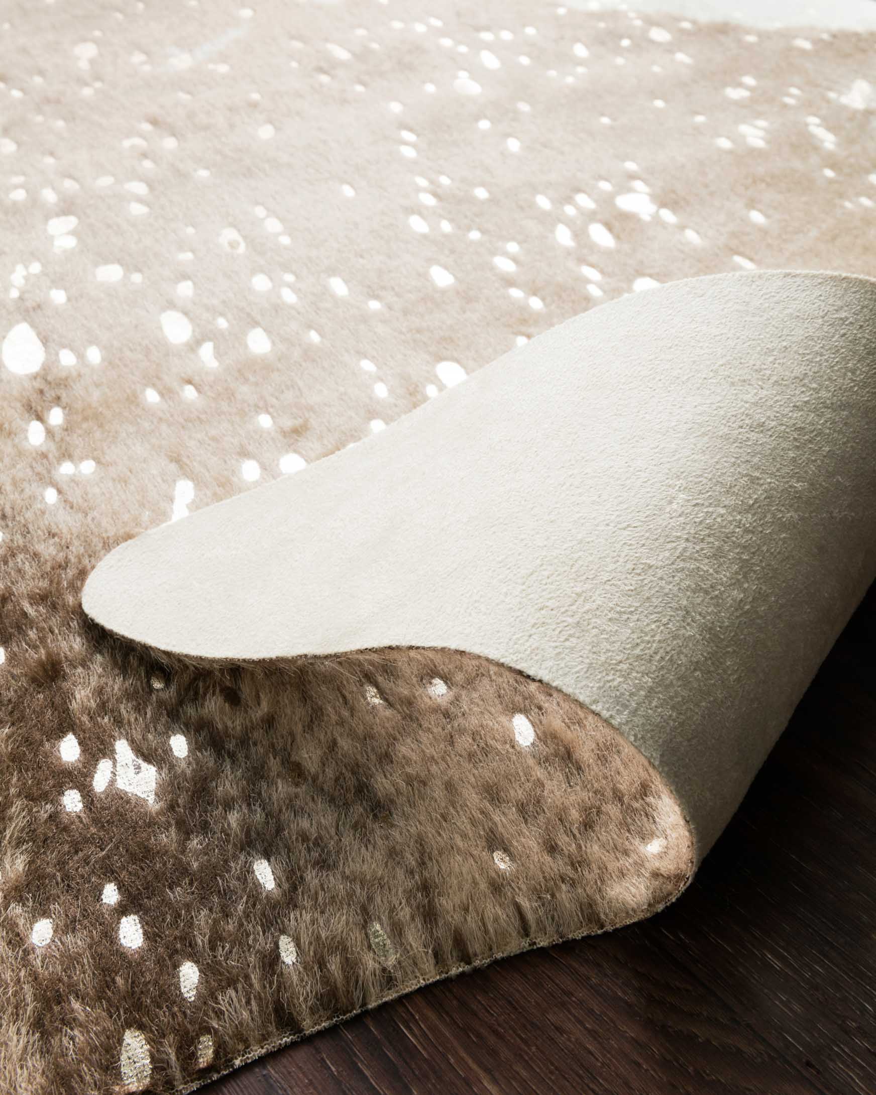 Taupe and champagne rug edge with speckled pattern and visible short pile