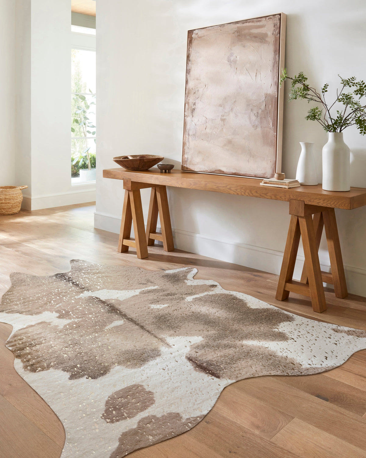 Taupe and champagne cowhide-style rug with large irregular spots and speckled accents