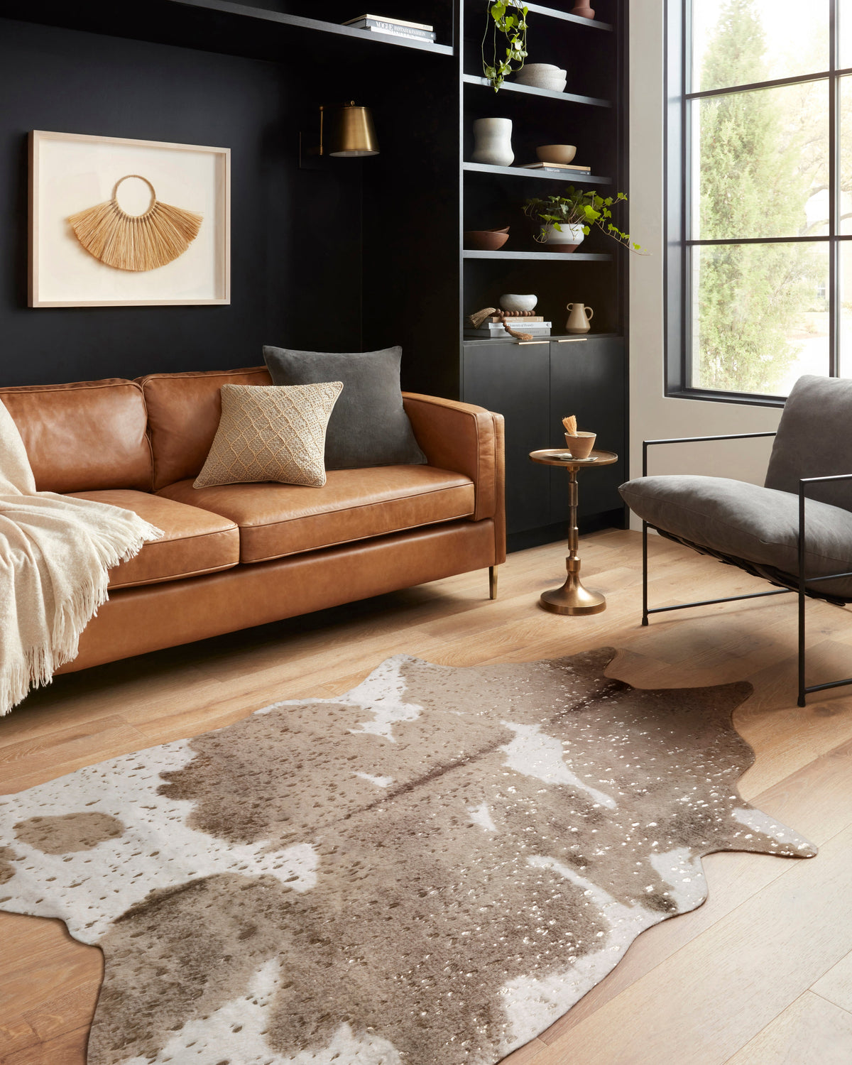 Taupe cowhide-style area rug with irregular blotches and white speckling
