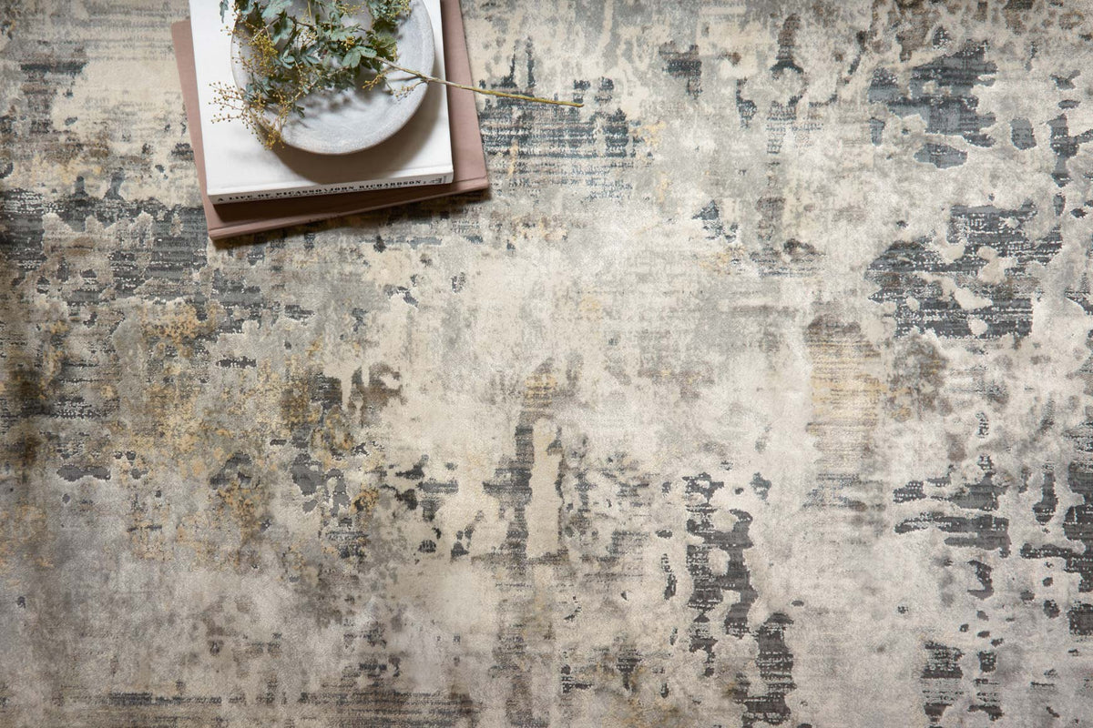 Ivory area rug with close-up distressed abstract pattern and blue-gray speckling.