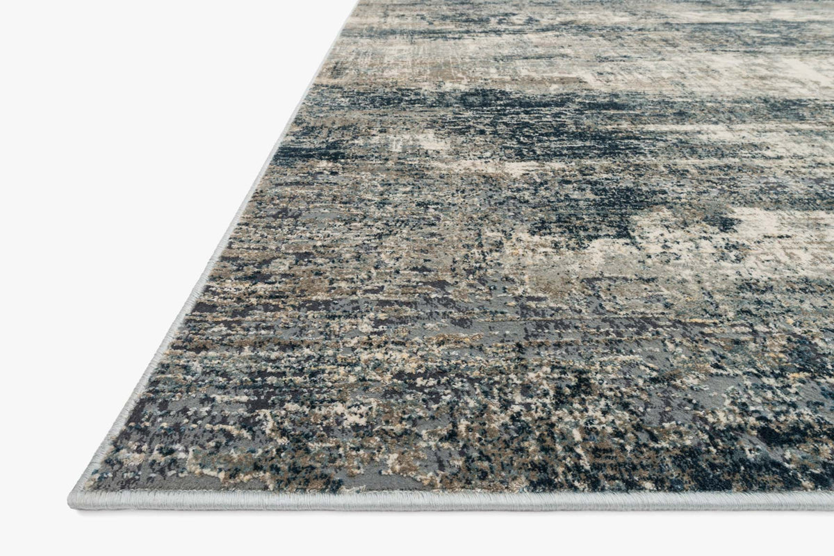 Angled view of power-loomed rug edge with ocean blue and grey distressed texture