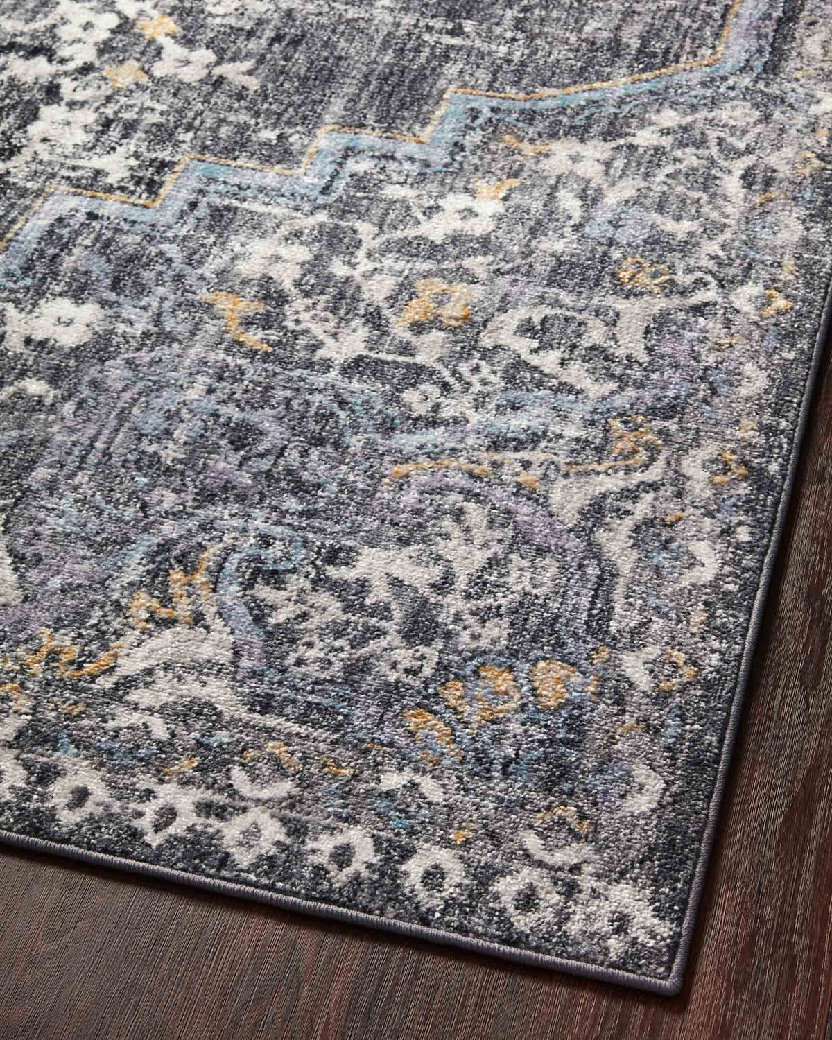 Charcoal rectangular rug with vintage motif and gold accents, close-up corner