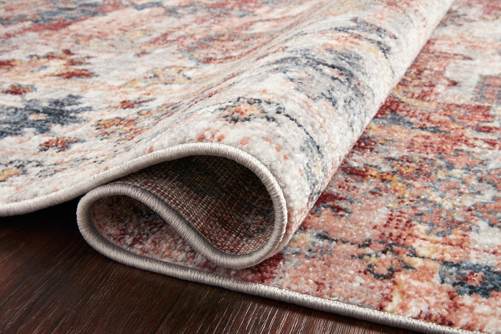 Rug edge detail showing low pile and folded hem in gray-trimmed border.