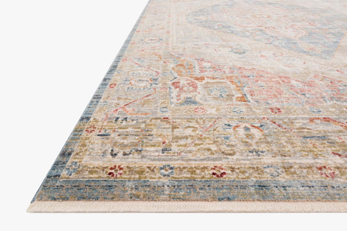 Traditional patterned rug corner with blue border and faded orange accents on light background