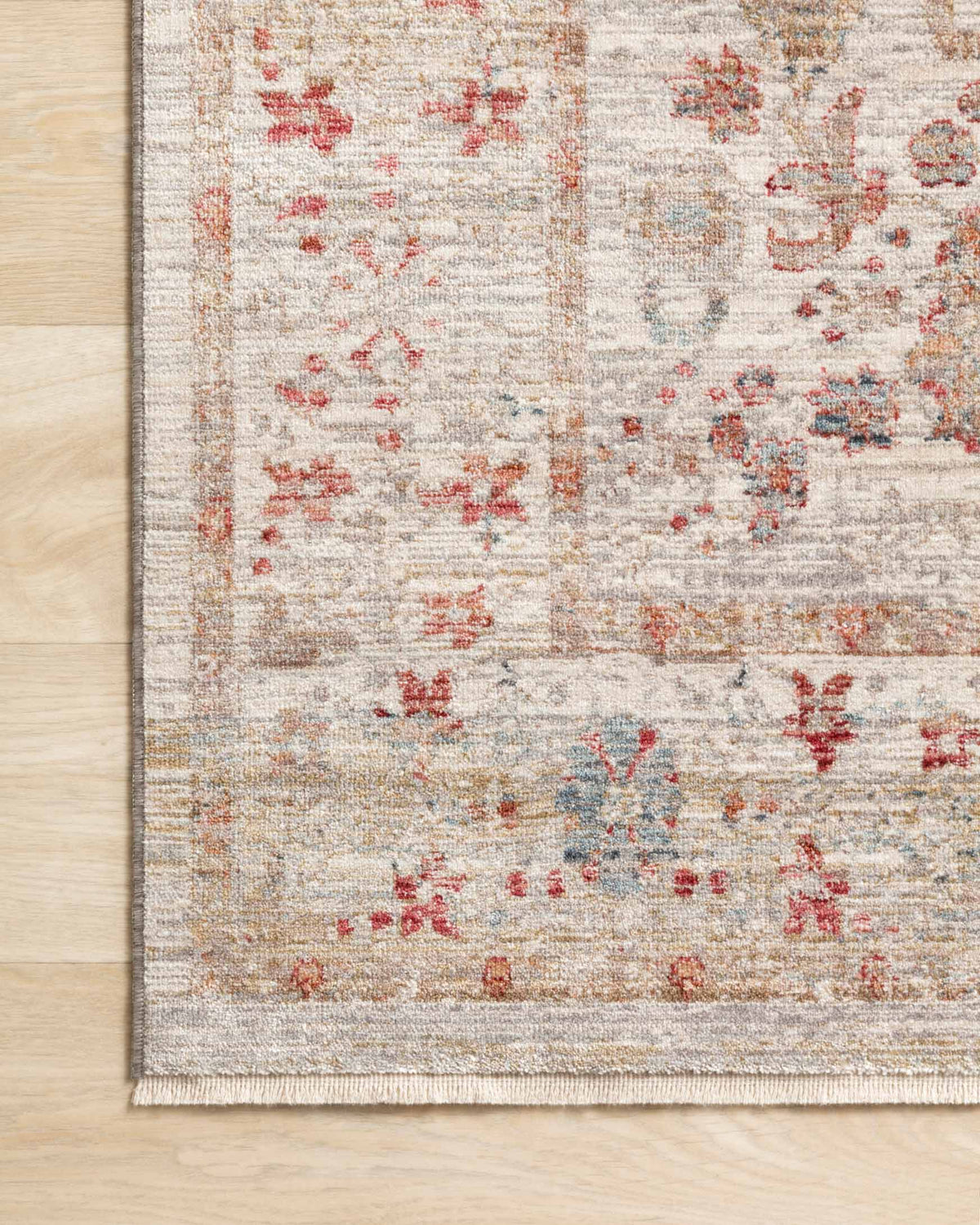 Ivory rug edge with densely woven distressed pattern and multicolor accents.