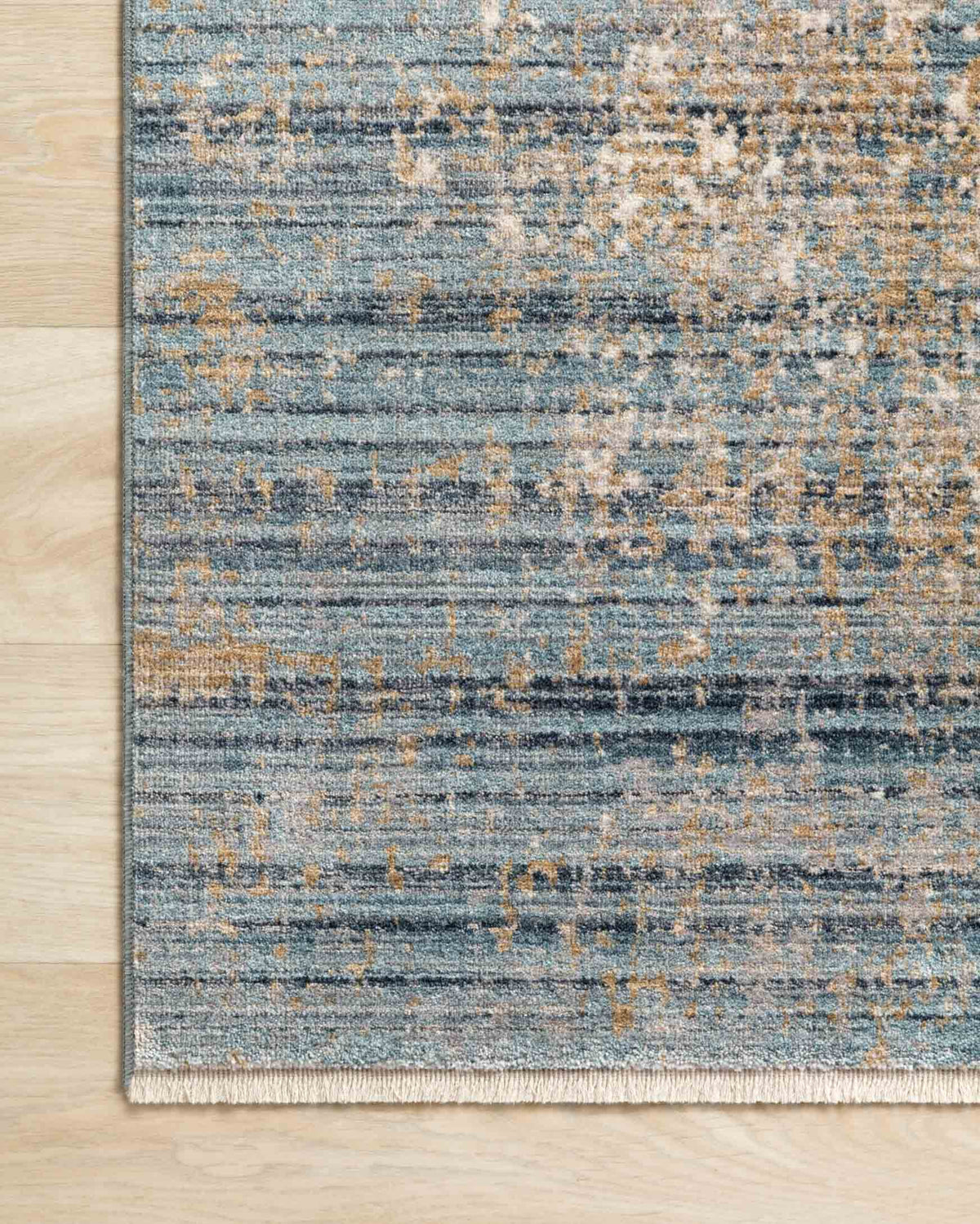 Rug edge detail in neutral beige and sea blue with dense distressed weave