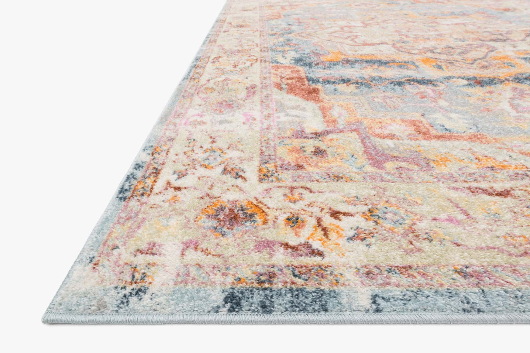 Transitional rug edge view with ivory, light blue and rust mottled geometric pattern