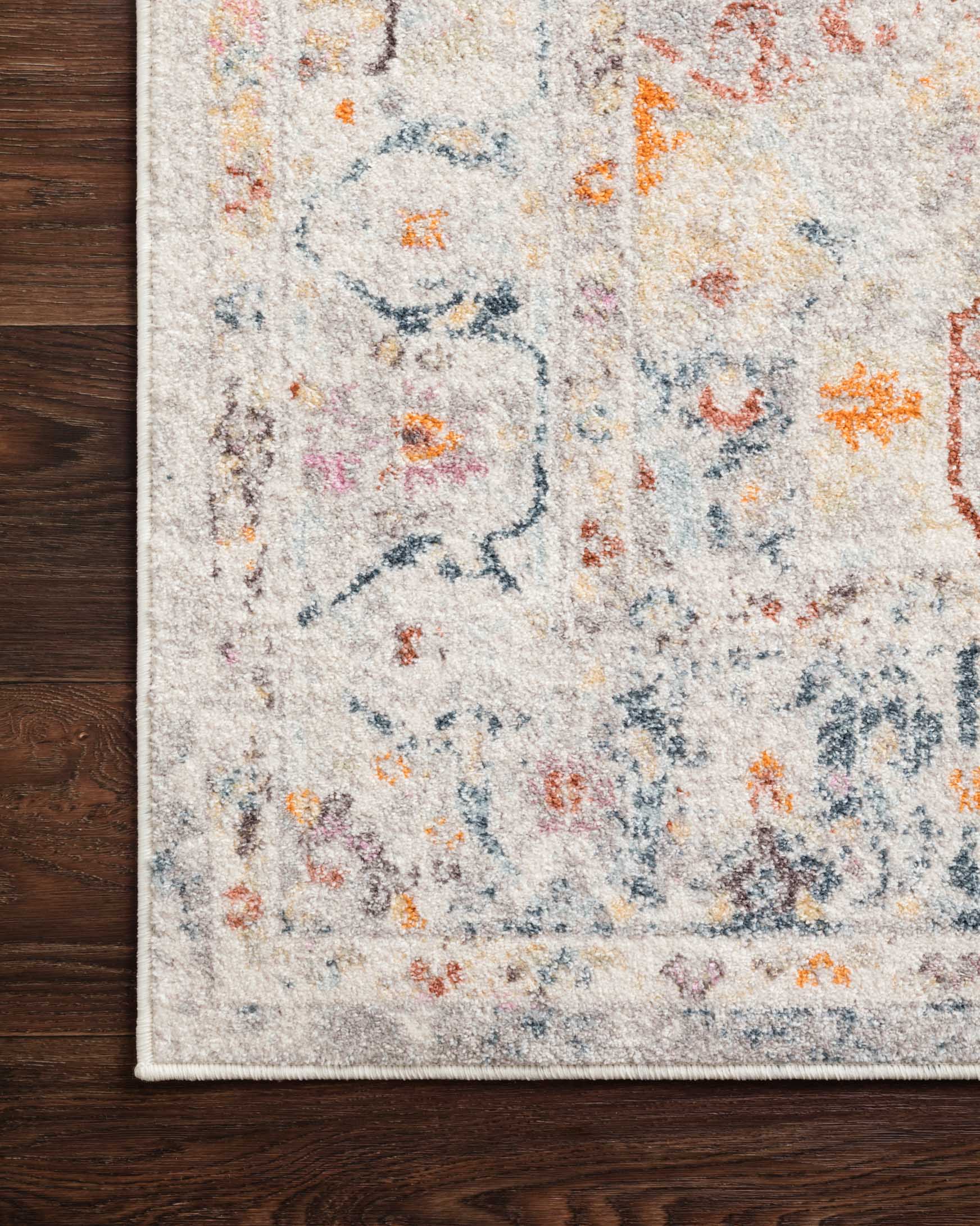 Light grey rug border with distressed pattern and speckled orange and blue details