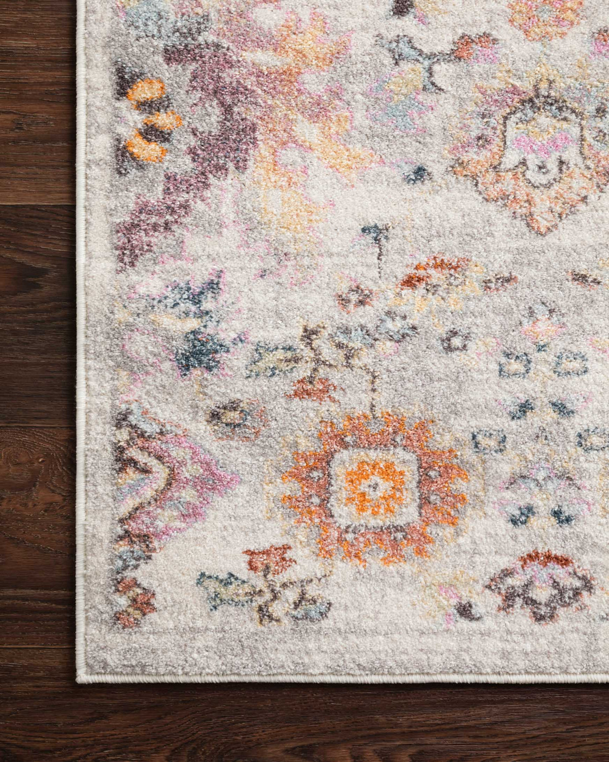Close-up of light gray rug surface with multicolor distressed medallion pattern