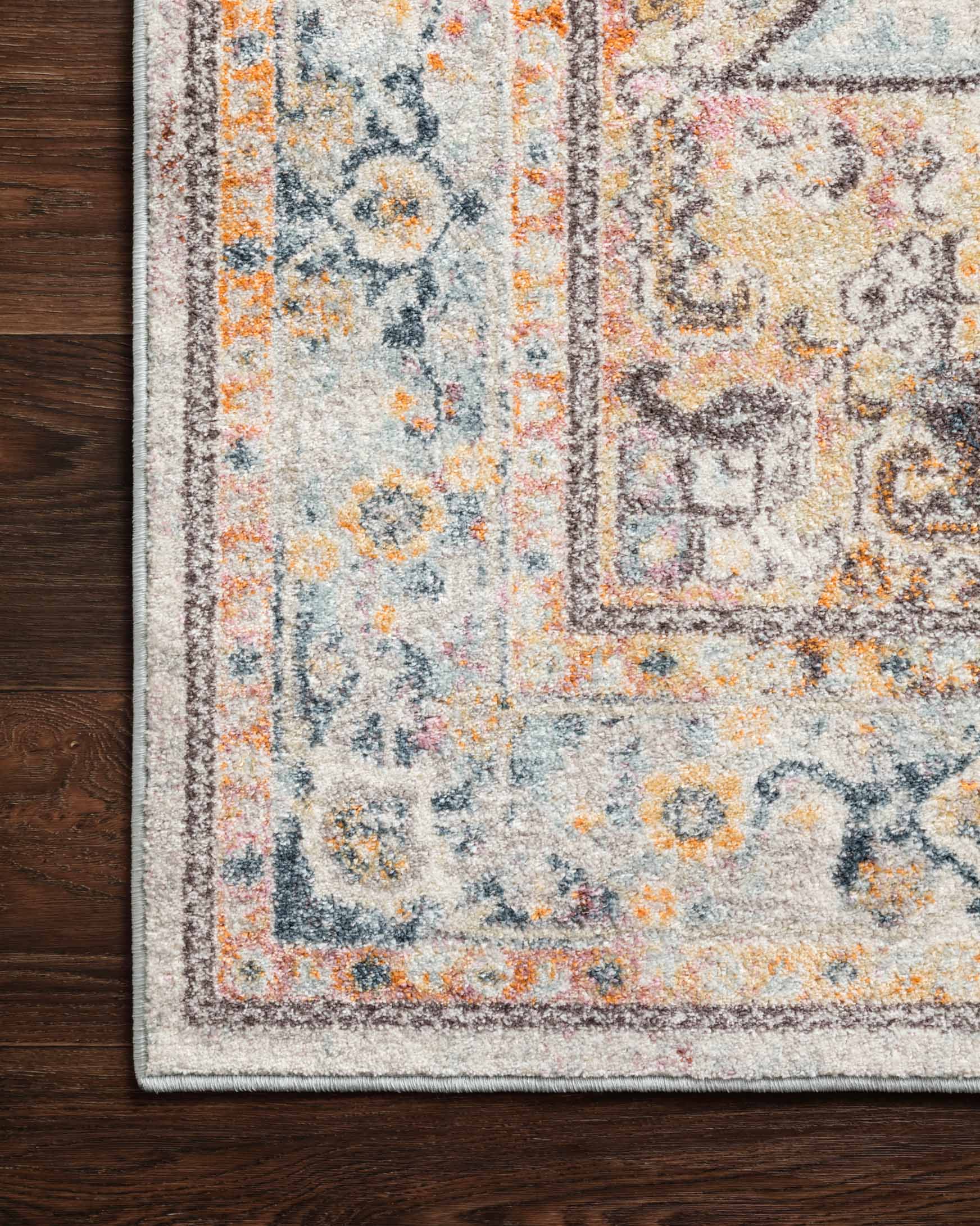 Close-up of rug border and medallion motifs with mottled blue, cream, and orange highlights