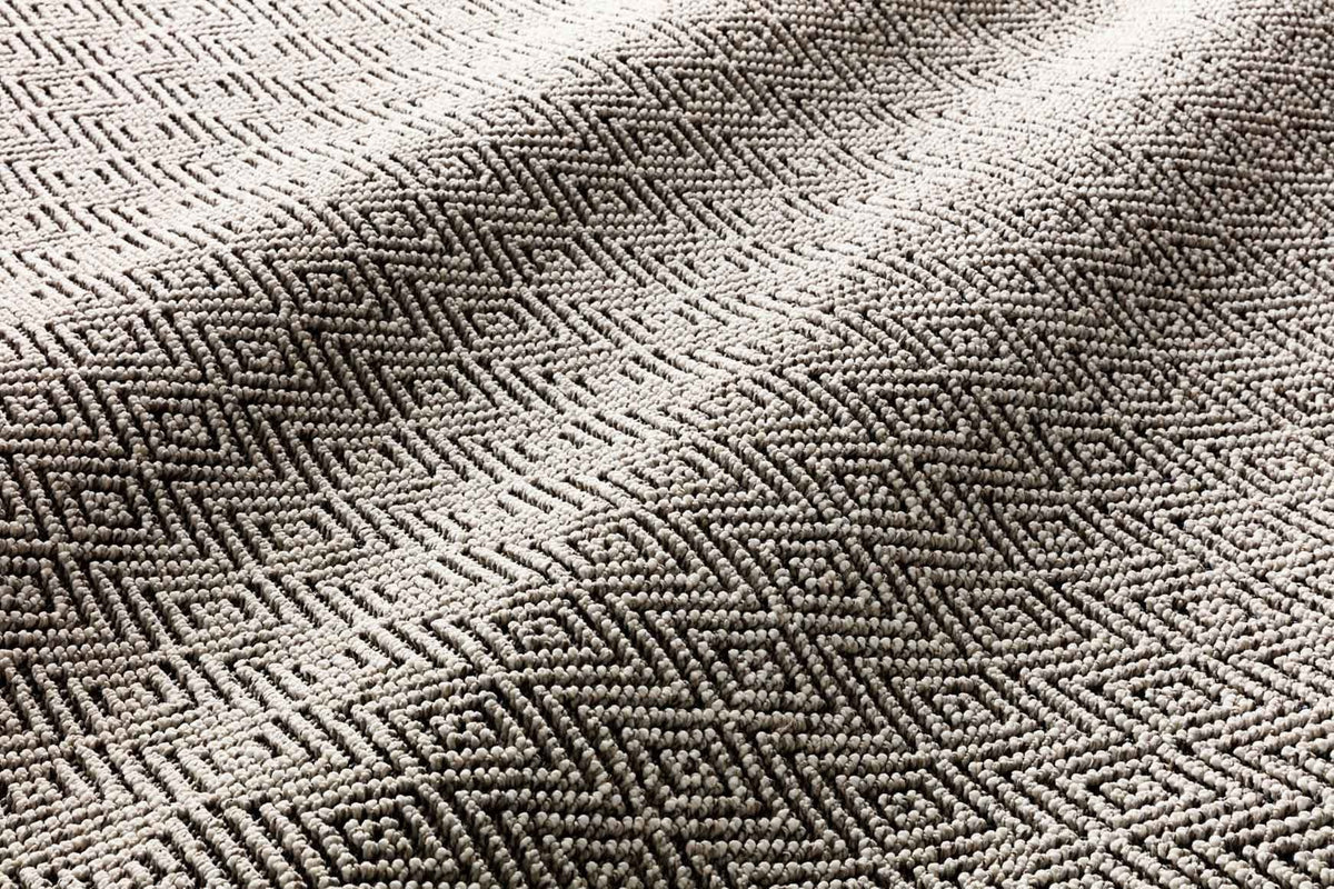 Close-up of grey and bone rug texture with repeating chevron diamond pattern