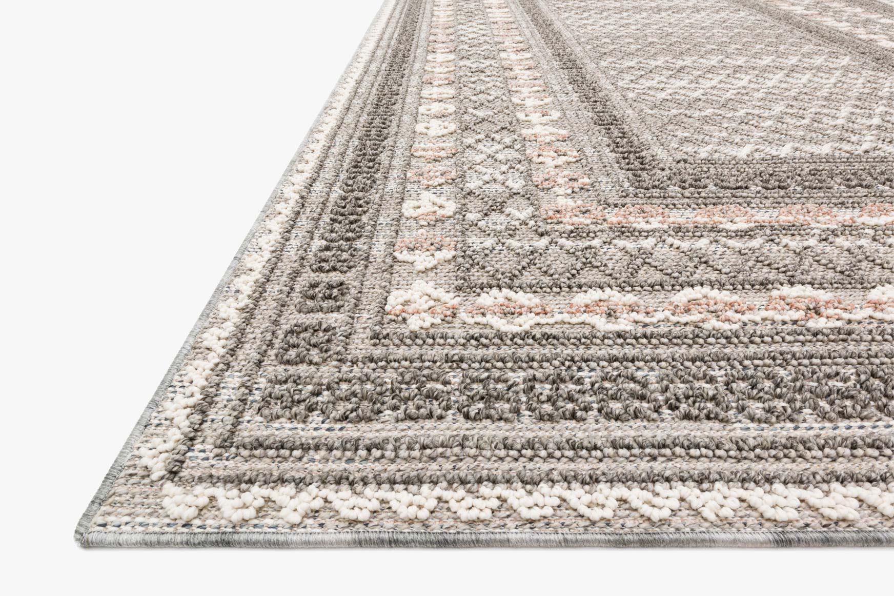 Corner view of grey, beige, and cream textured rug with geometric border and short pile