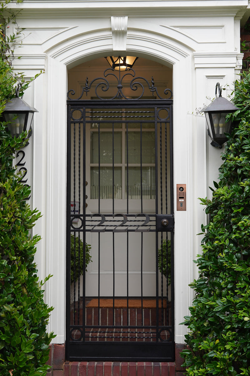 Bronze flush-mount DoorBird video door station mounted on front gate with call button
