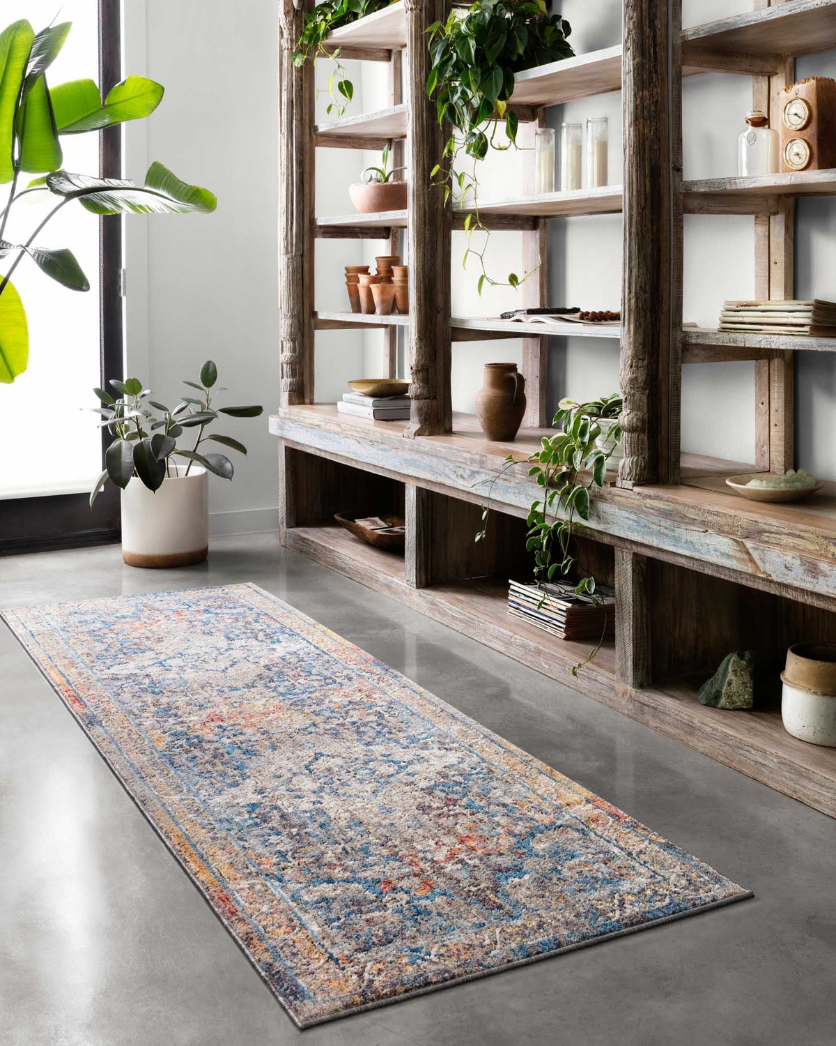 Transitional power-loomed rug in blue and stone with ornate border pattern and multicolor speckle.
