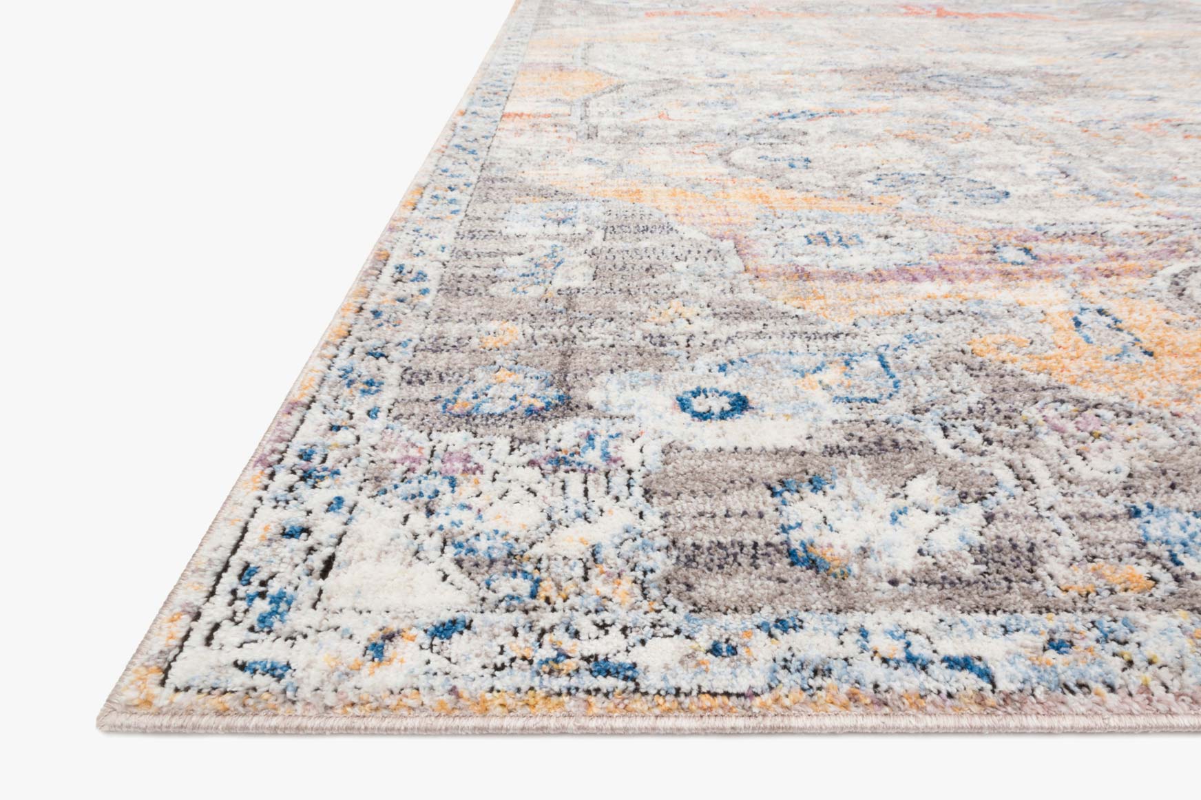 Close-up of abstract rug pile showing light gray, blue, and orange speckled pattern