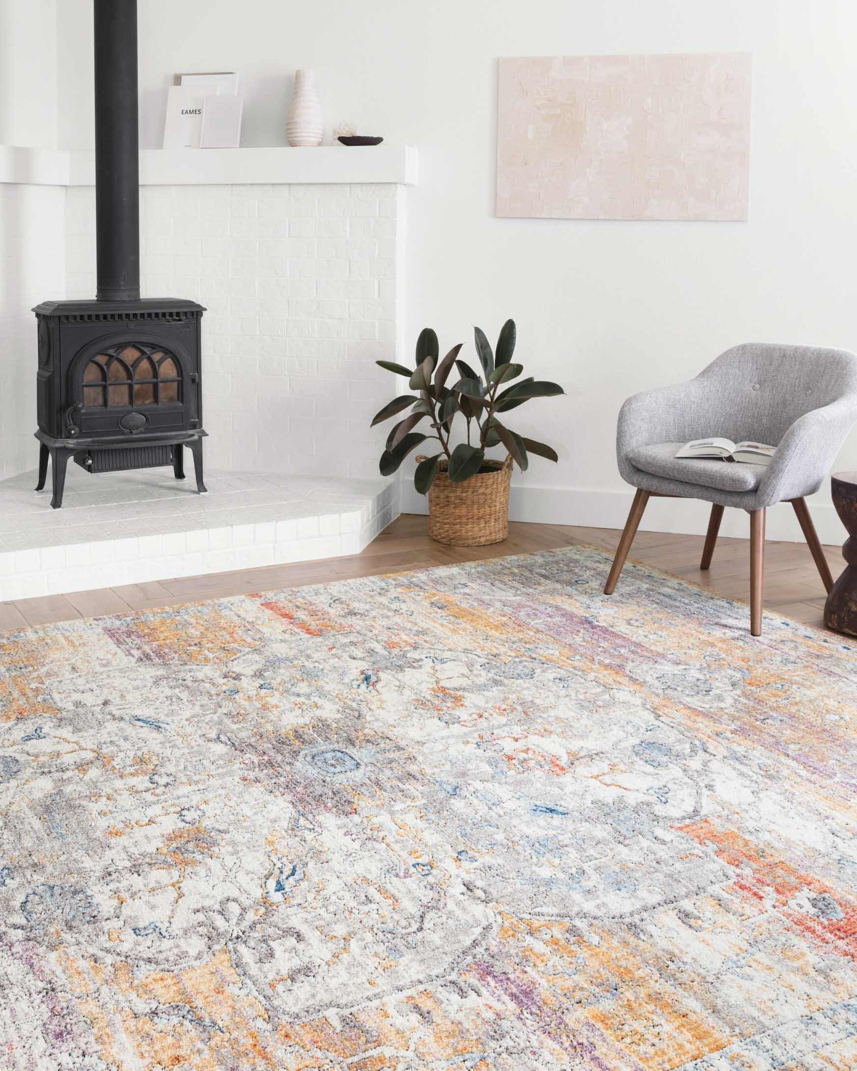 Abstract area rug with light gray and beige base, blue details, and orange accents