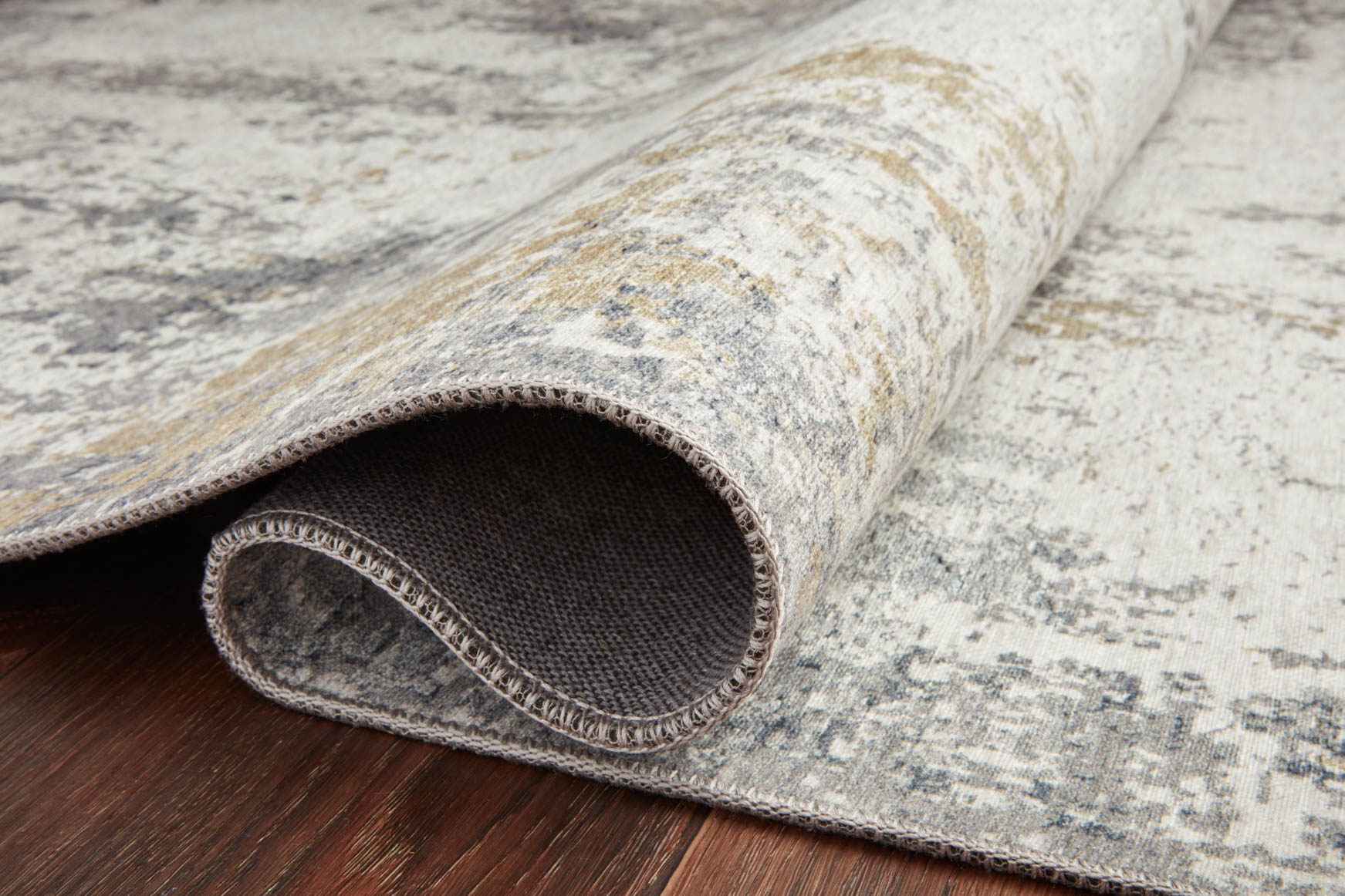 Ivory and gray rug with rolled edge, short distressed fibers and woven texture.