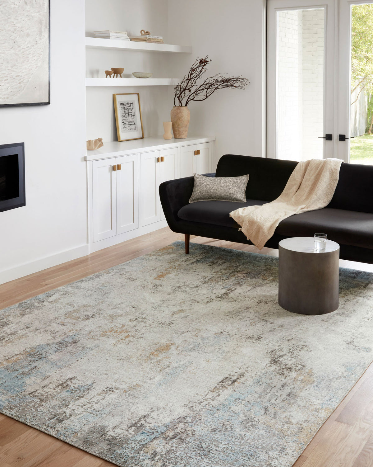 Antique distressed rug with gray, ivory, and light blue abstract pattern on floor