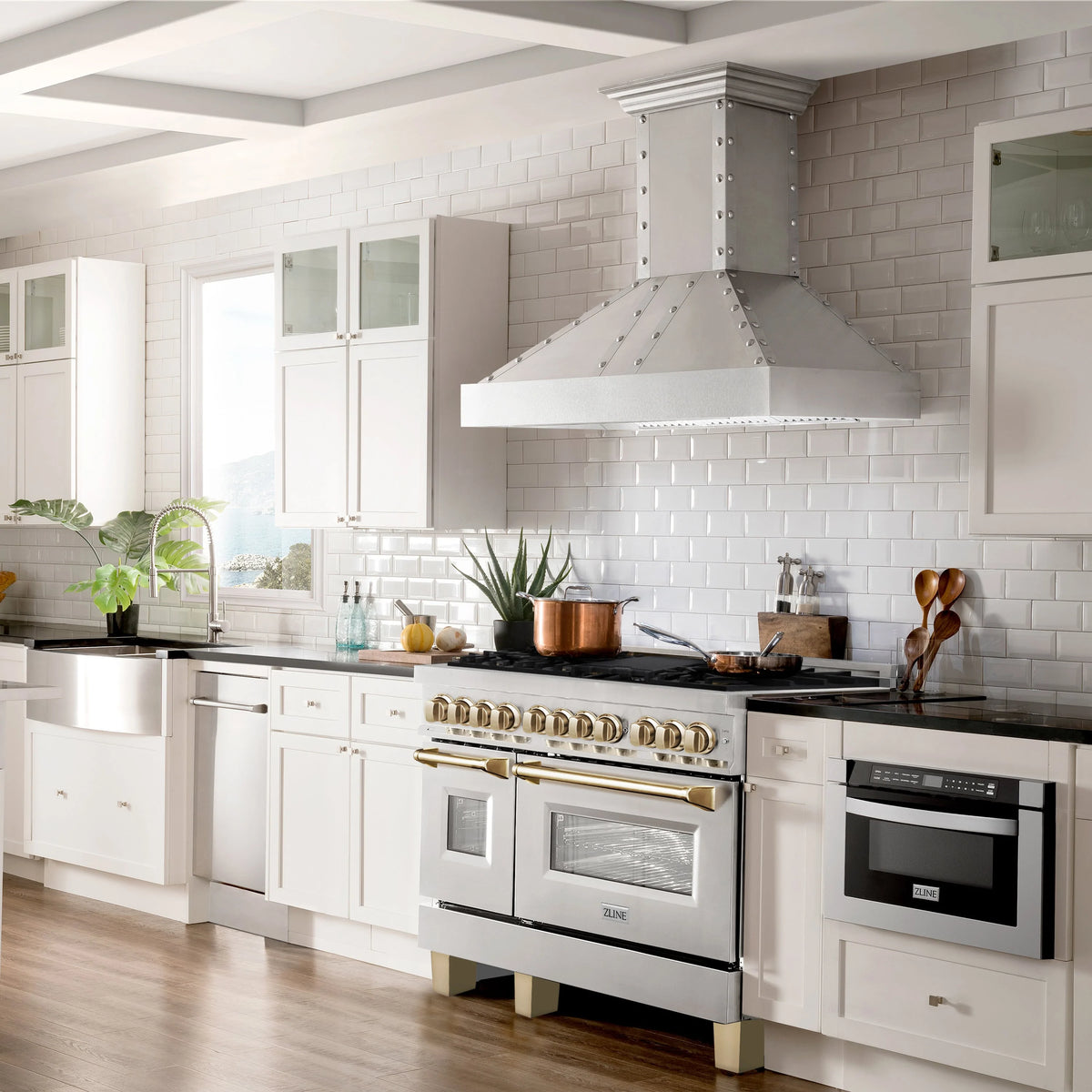 Stainless range and wall hood with gold trim and dual ovens