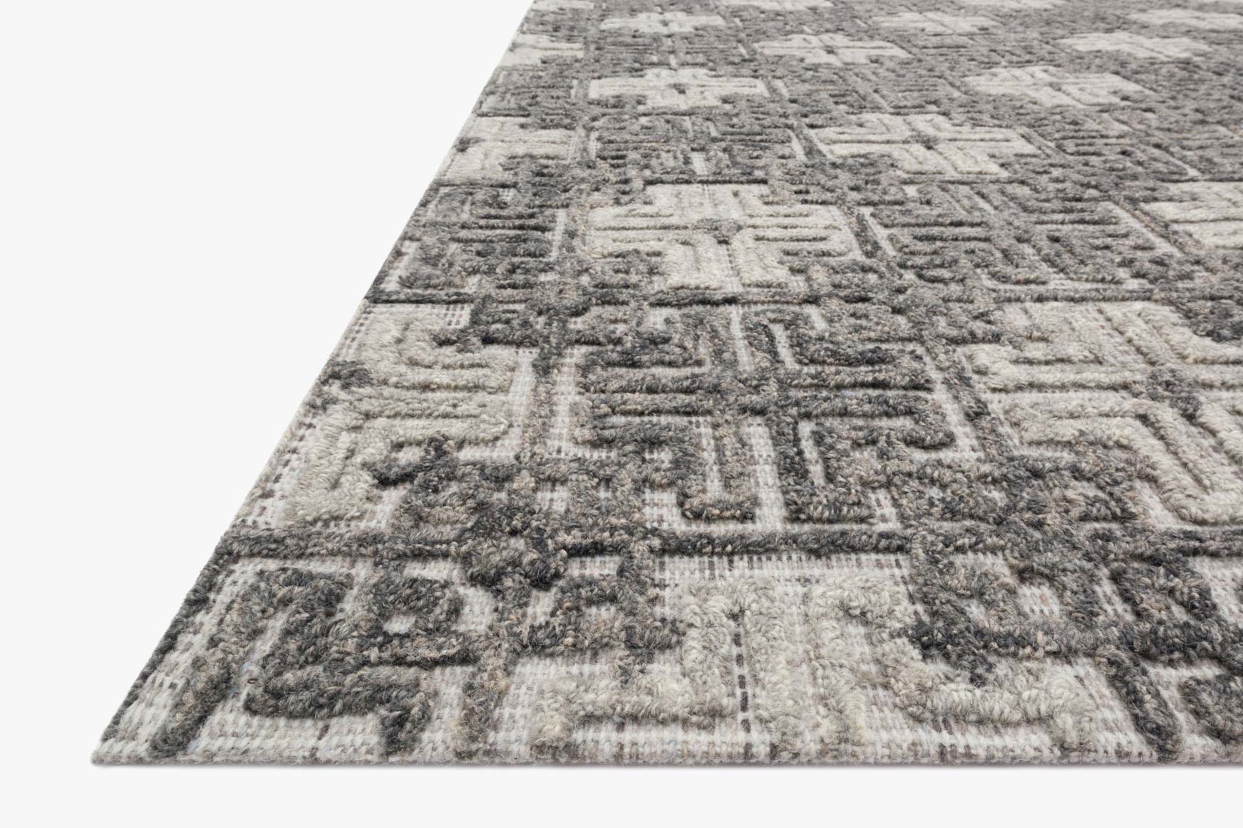 Contemporary hand-tufted rug in charcoal and fog, textured geometric pattern, angled corner