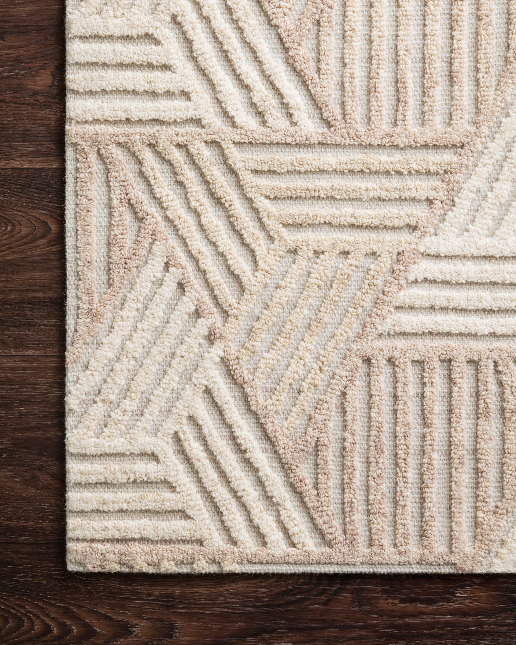 Corner view of oatmeal and ivory rug showing raised geometric stitch detail