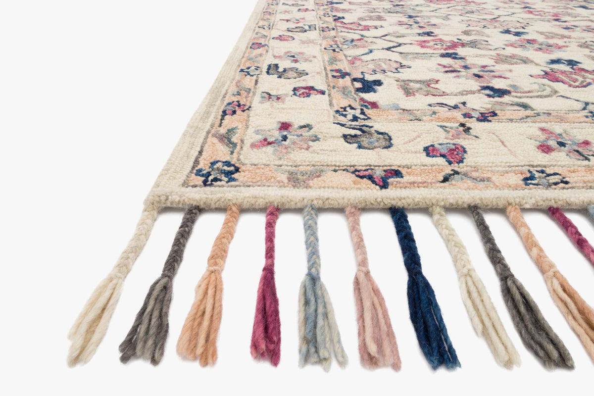 Ivory hooked rug corner with multicolor tassel fringe and detailed floral geometric pattern