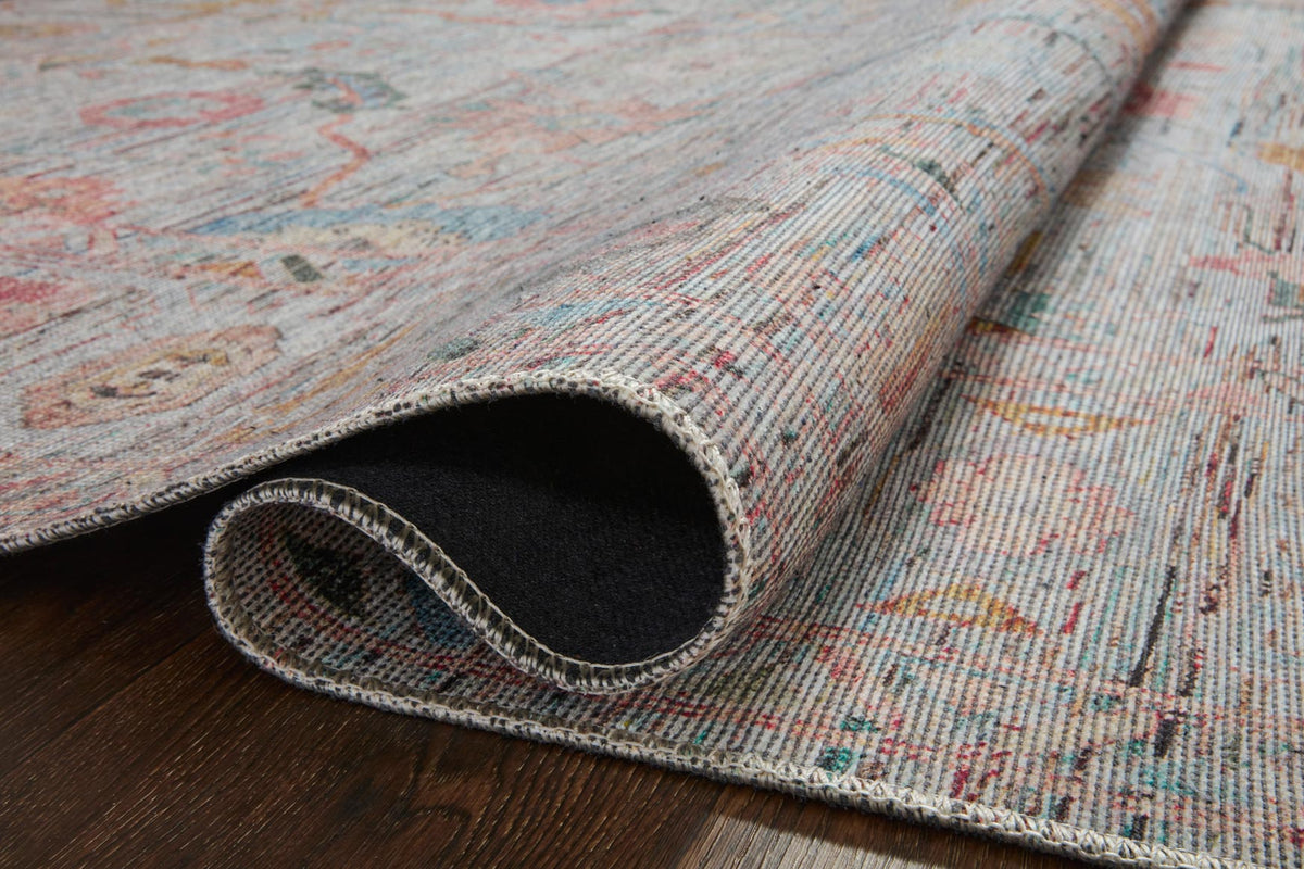 Rug edge close-up showing multicolor pile and dark underside backing