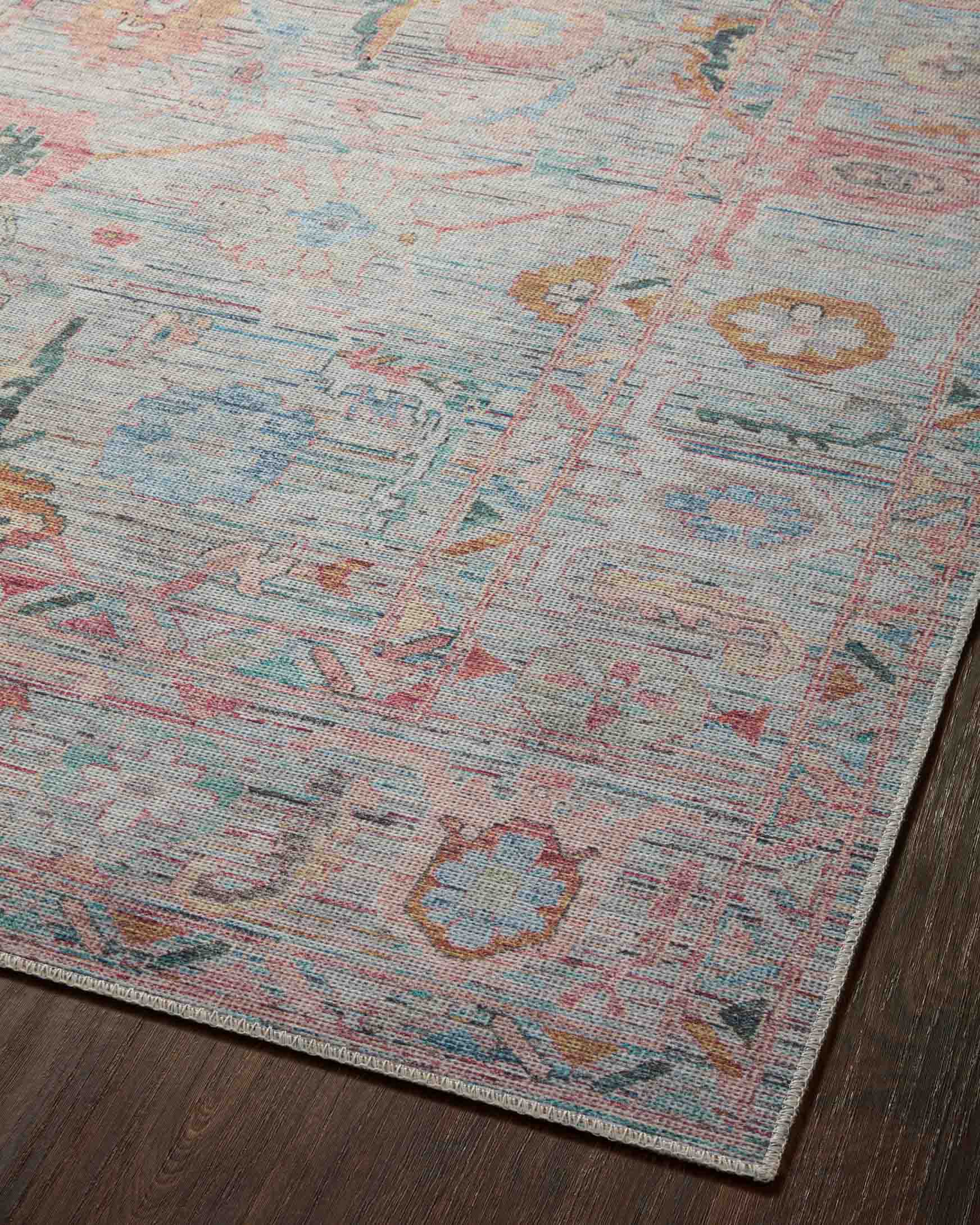 Flat view of traditional area rug with light blue field and multicolor geometric motifs