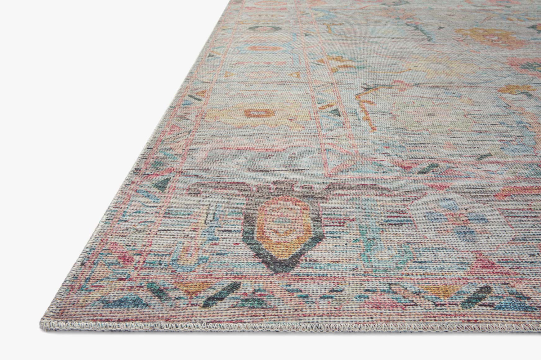 Traditional area rug corner with light blue ground and distressed multicolor design