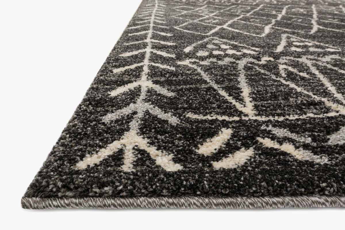 Black and white rug corner with abstract geometric lines and textured pile edge