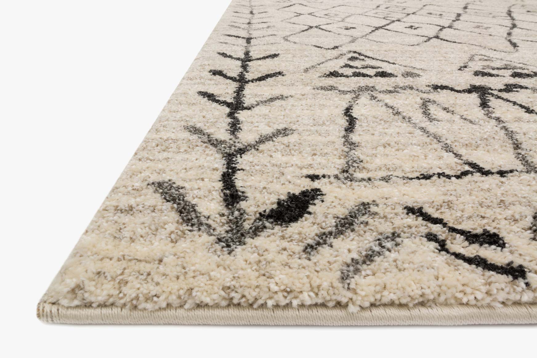 Corner detail of heather gray area rug with black pattern and short fringes