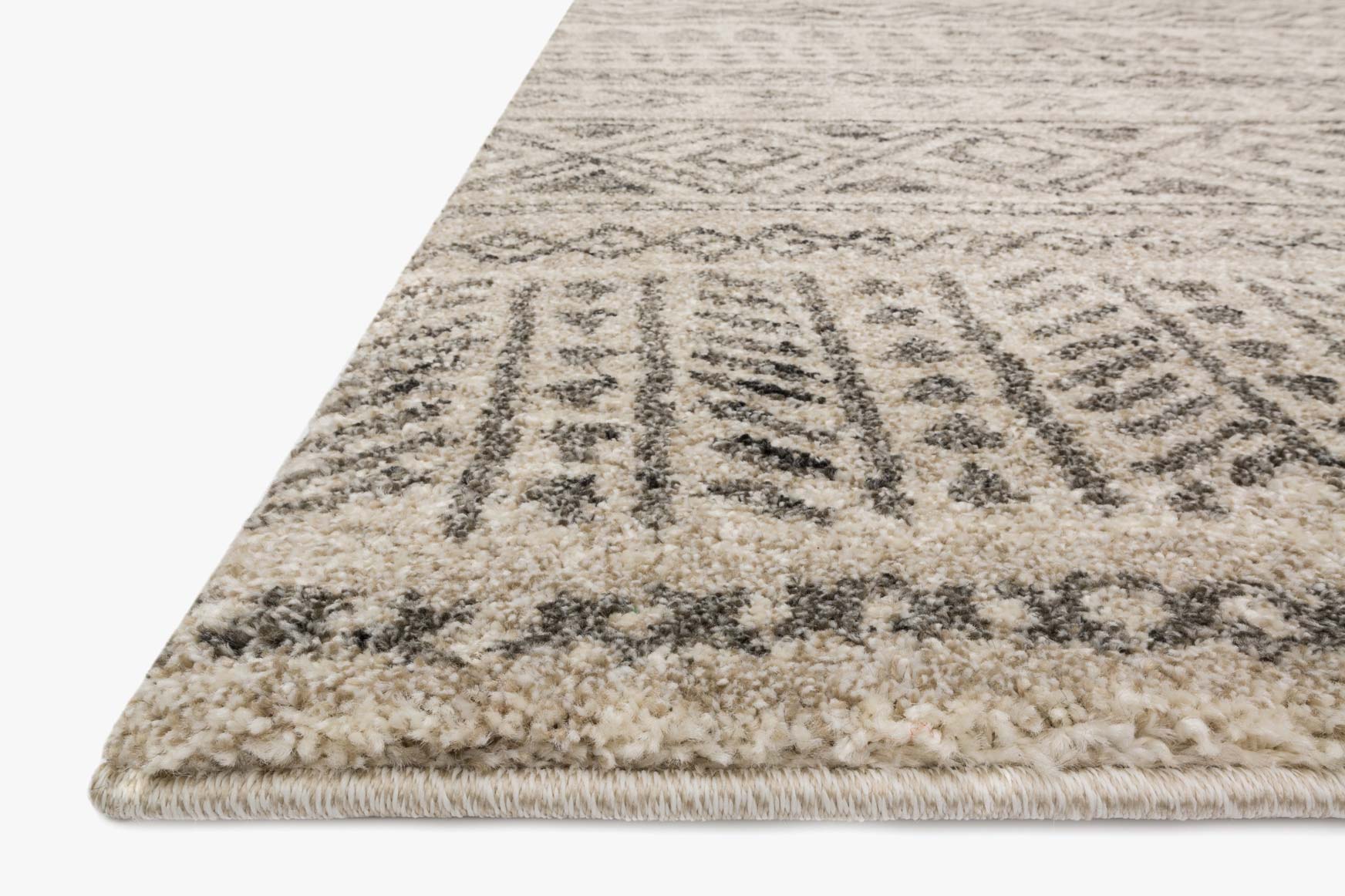 Corner view of stone and graphite power-loomed rug with textured pile and geometric medallion