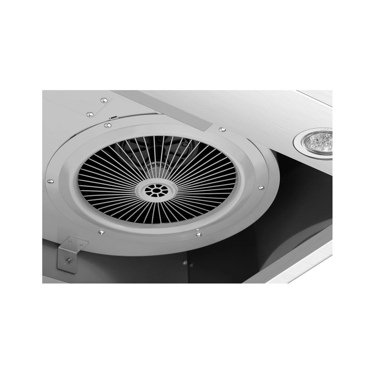 Close-up of circular fan with grille inside stainless steel range hood, plus light