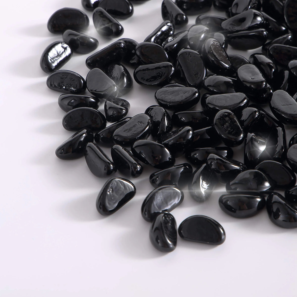 Close-up of onyx black tempered fire glass cashews, reflective pebbles