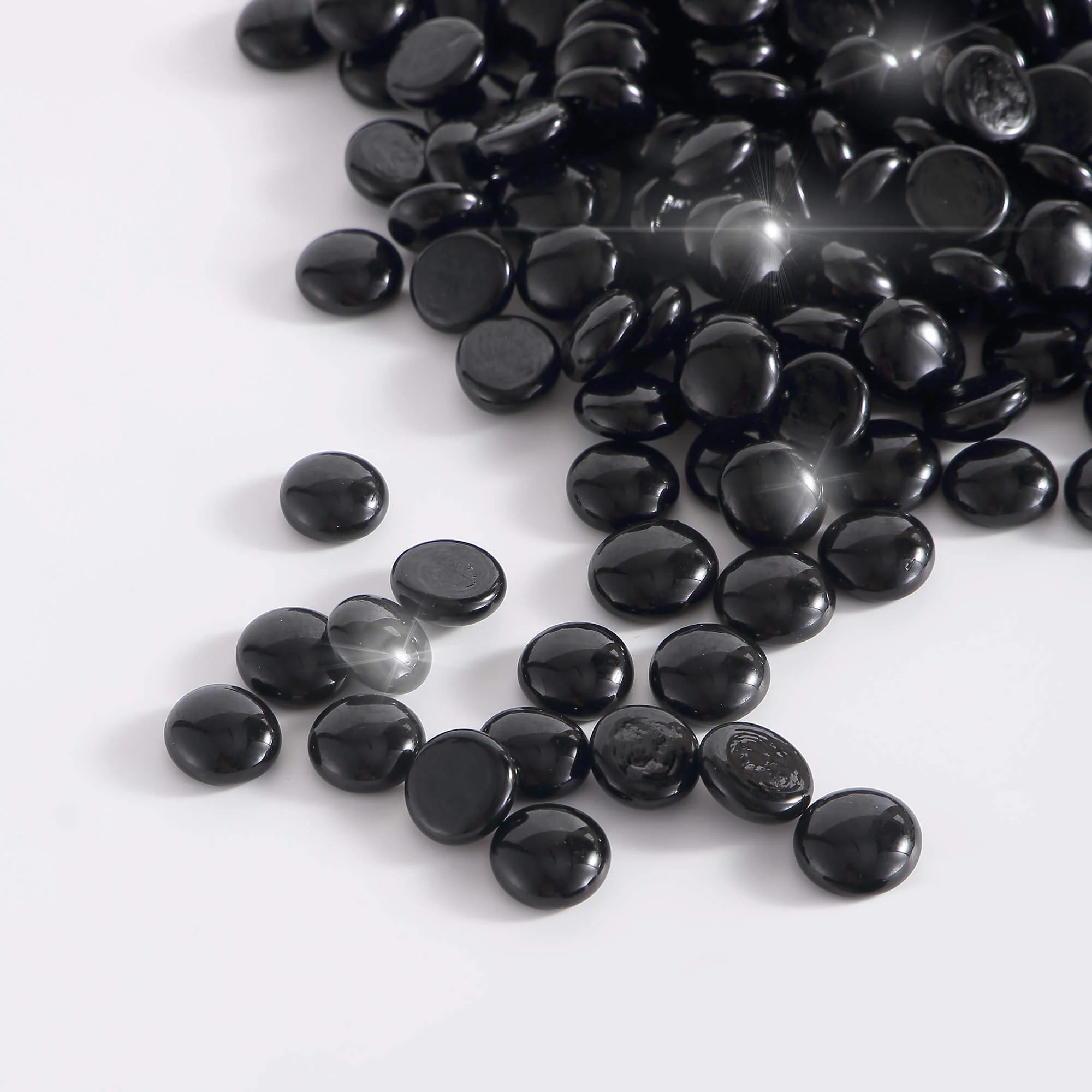 Onyx black tempered fire glass beads, glossy oval pieces close-up