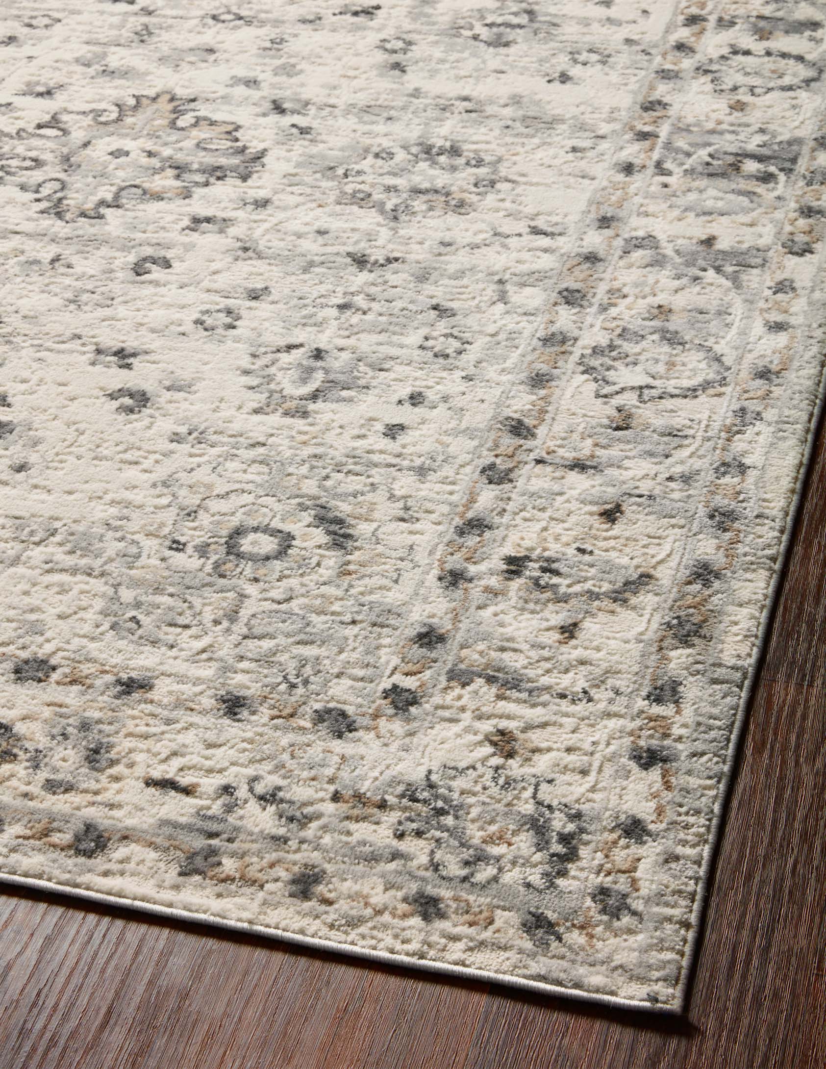 Close-up of rug corner showing textured pile and distressed pattern along border