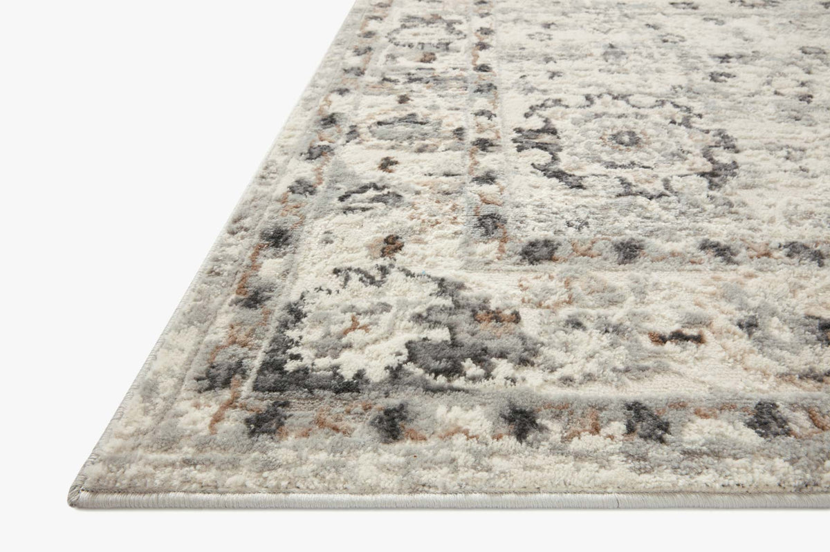 Corner view of ivory and stone distressed rug with vintage medallions and border lines
