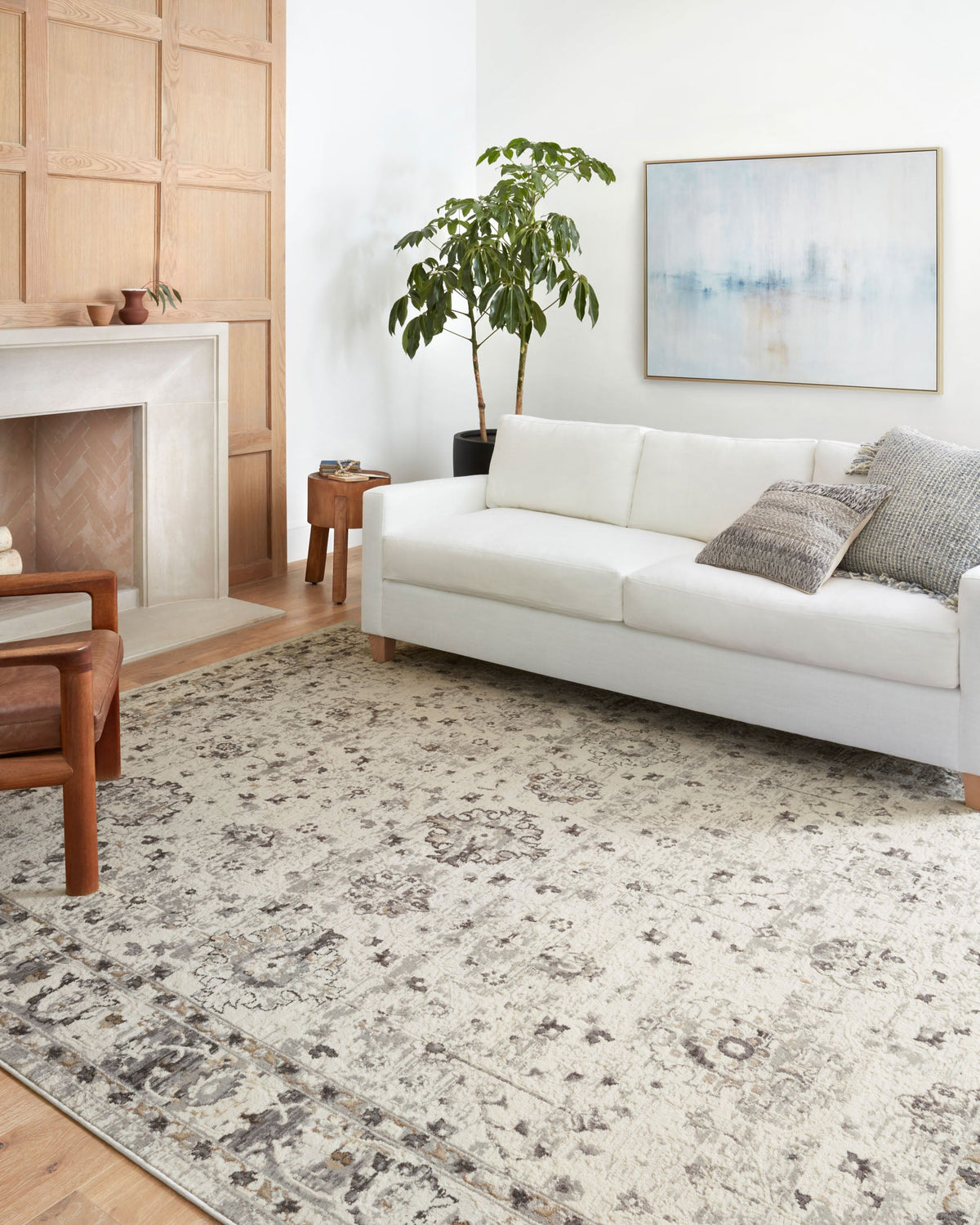 Ivory and stone patterned power-loomed rug in living room with distressed motif