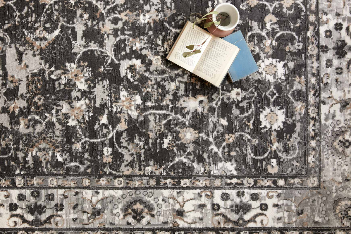 Charcoal and grey rug close-up with distressed floral and scroll pattern