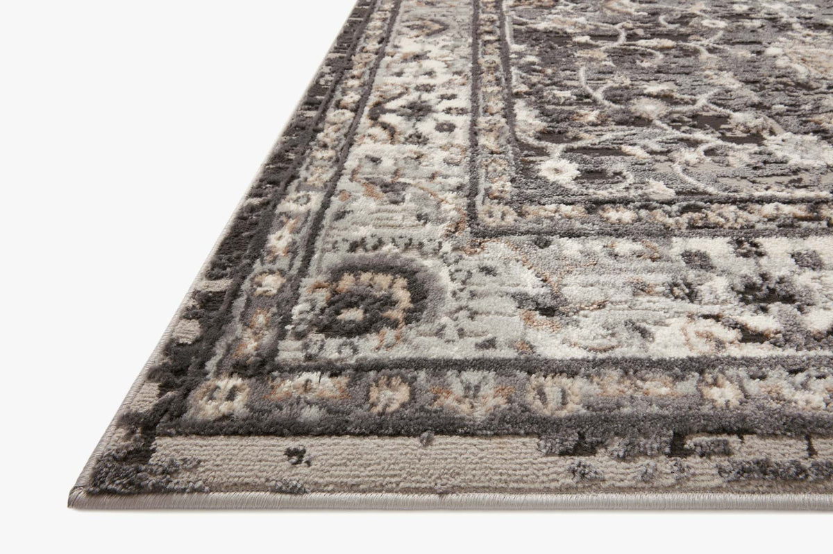 Charcoal and grey rug corner detail with bordered motif and woven edge