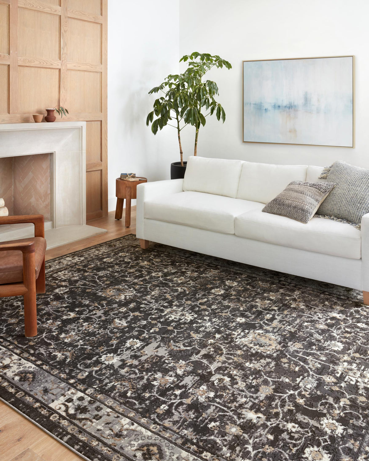 Charcoal and grey area rug with distressed floral motif and patterned edge