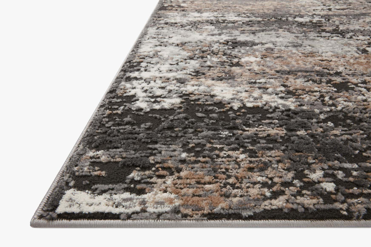 Close-up of charcoal and granite rug pile with mottled distressed pattern and angled border.