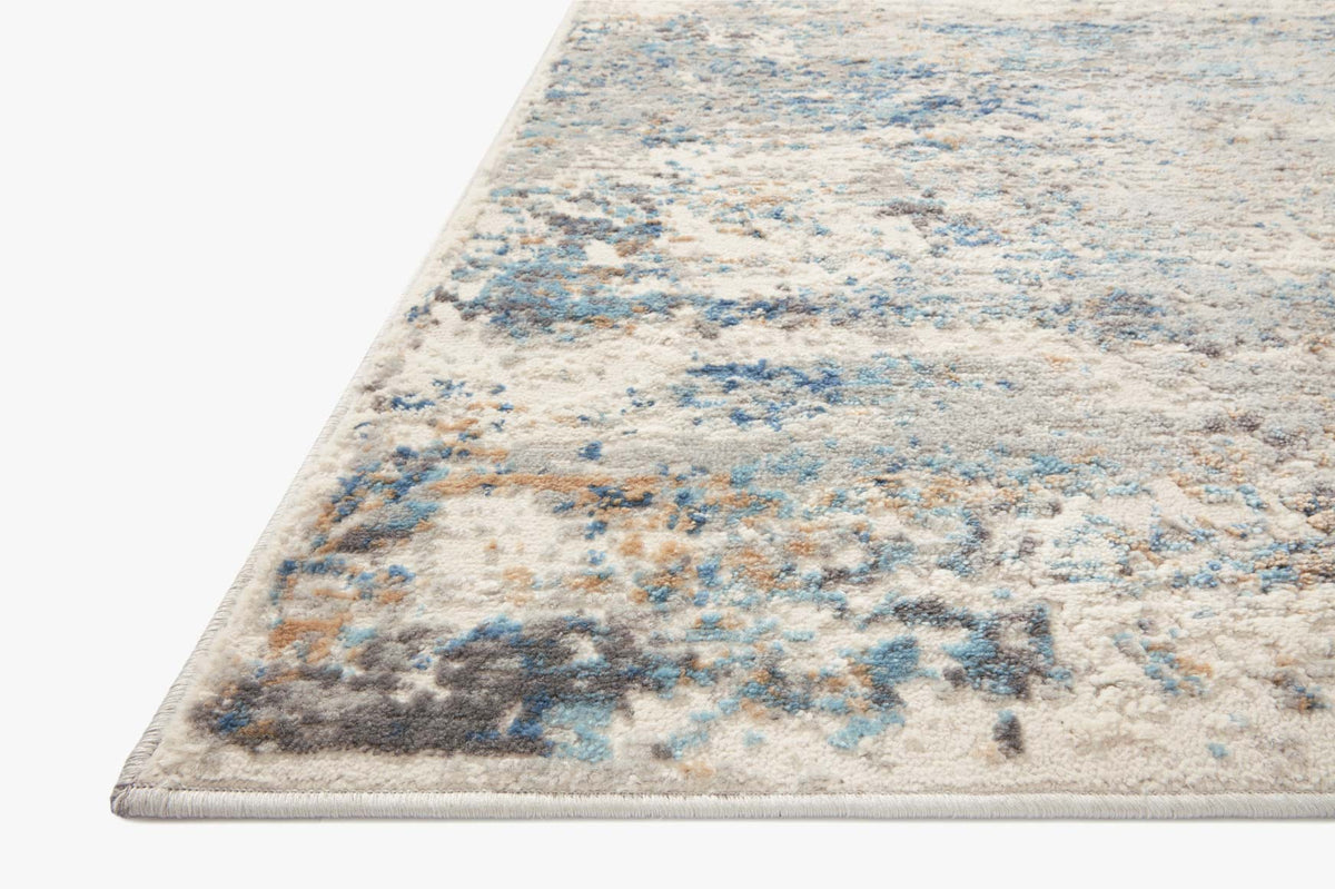 Ivory and ocean corner view of abstract distressed area rug with flat woven texture.