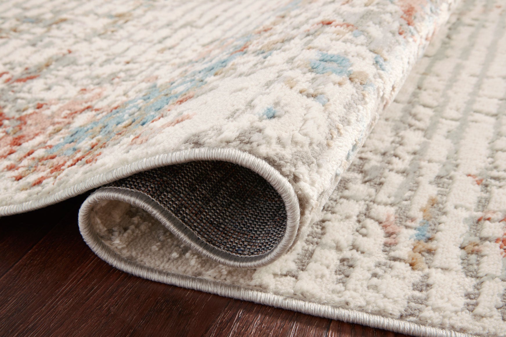 Close-up of ivory rug pile and border edge with visible texture in red and blue