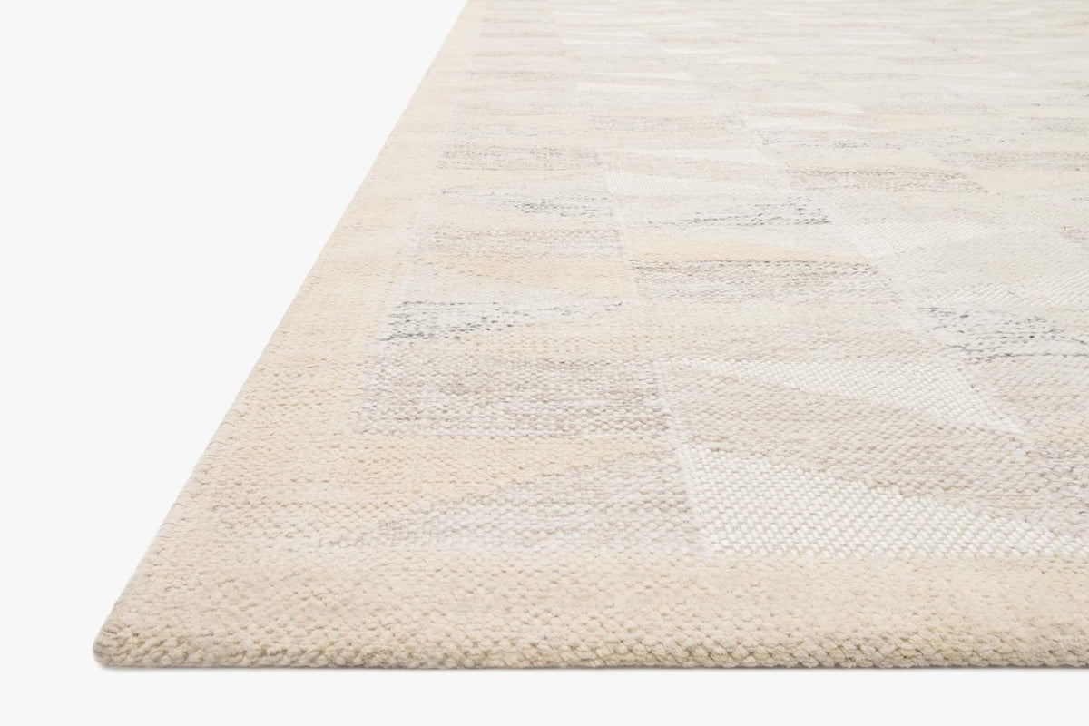 Natural hand-woven rug corner with textured surface and subtle abstract pattern stripe
