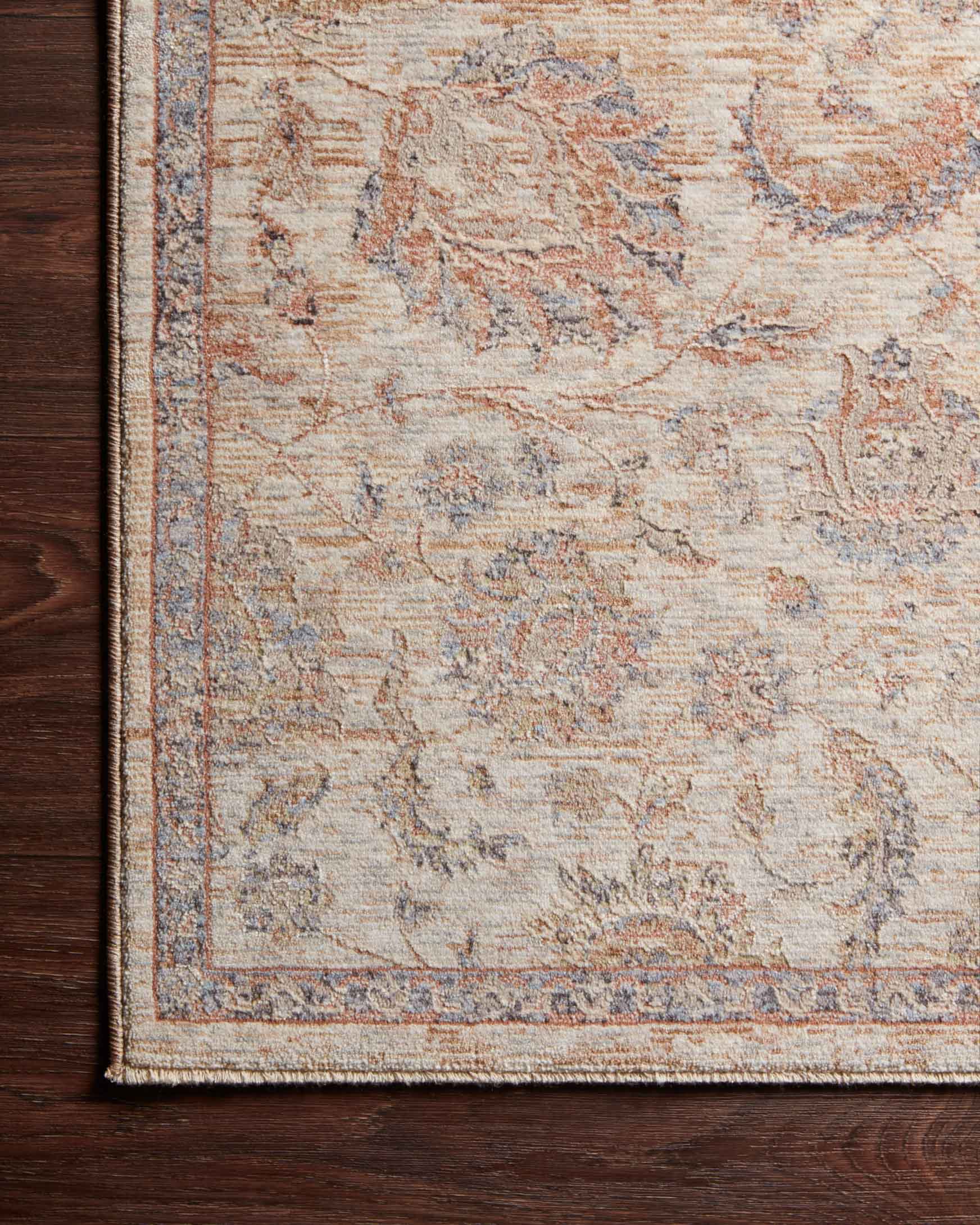Beige rug corner with distressed tone-on-tone pattern and detailed border