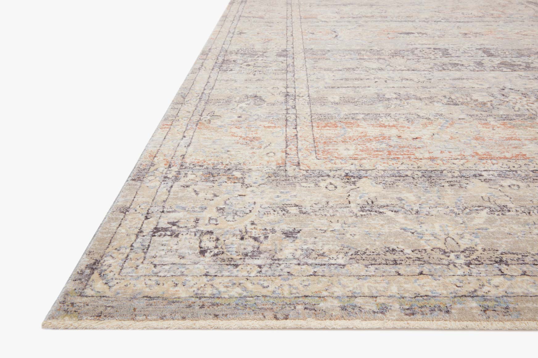 Corner view of power-loomed rug in beige with muted blue and orange-rust pattern