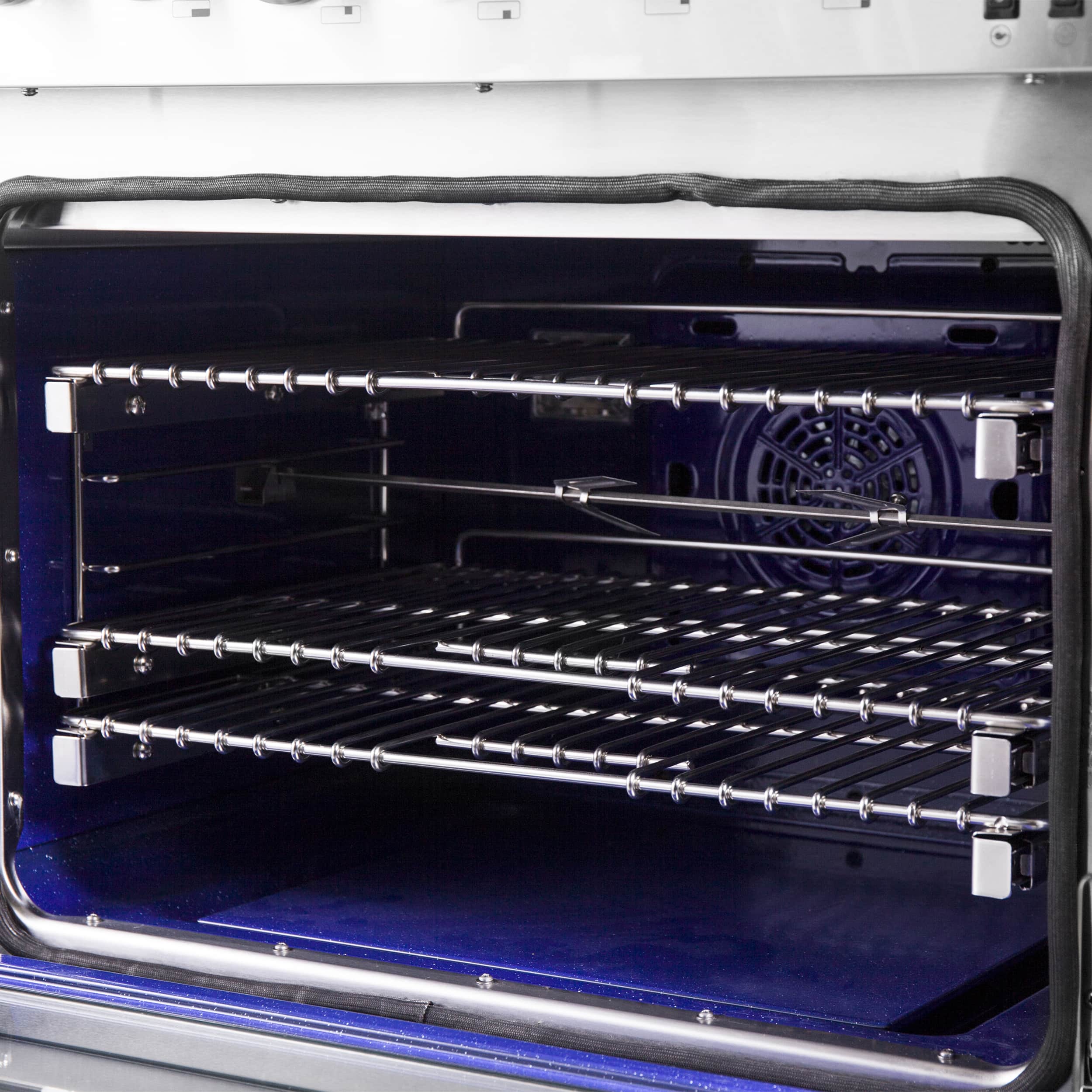 Dual fuel oven interior with two chrome racks and blue back panel