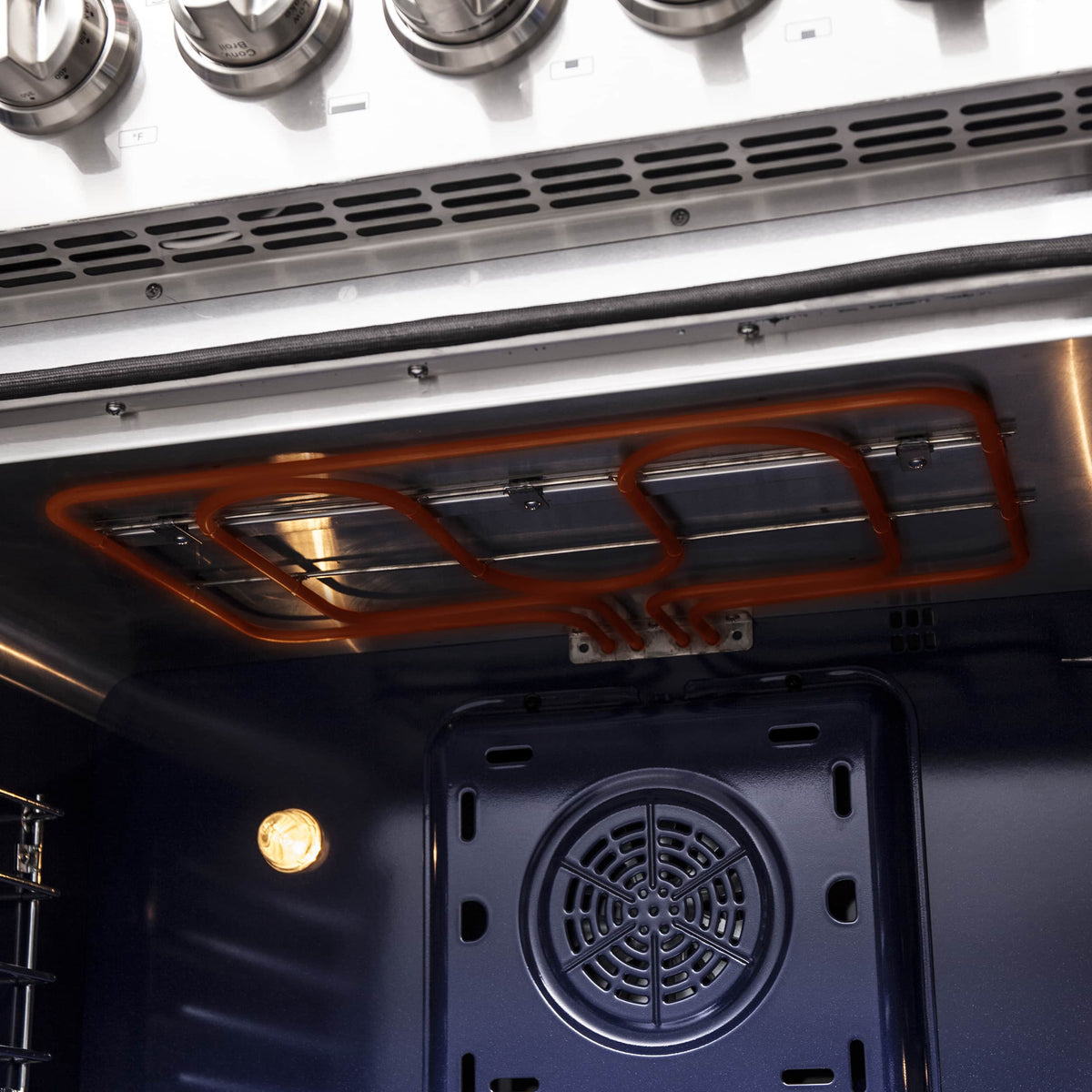 Open oven interior showing heating element, burner tubes, and convection fan vent
